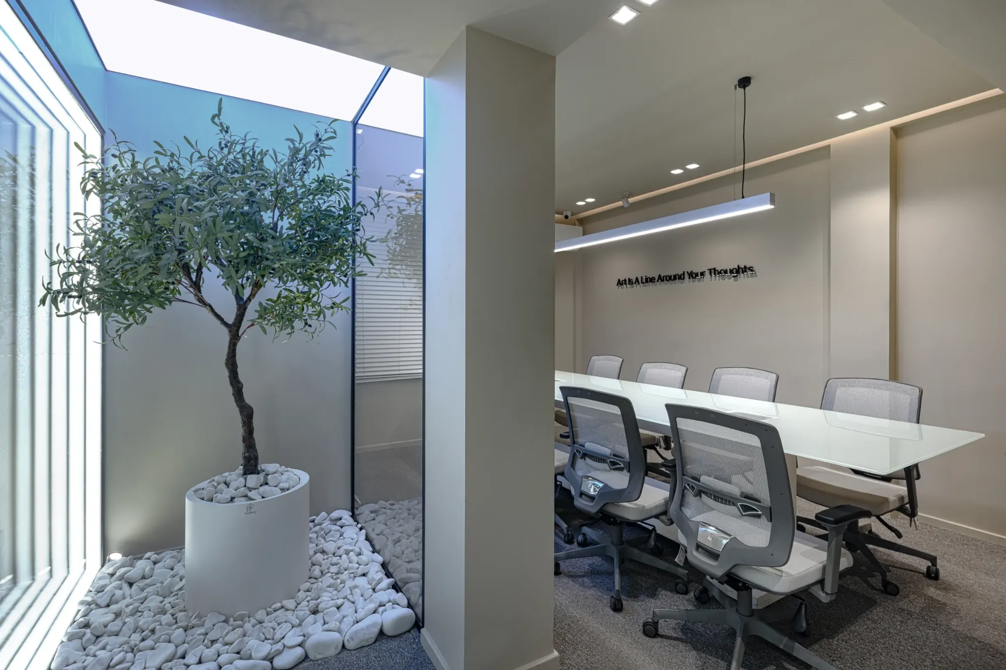 Meeting room beside a bright courtyard with a potted tree.